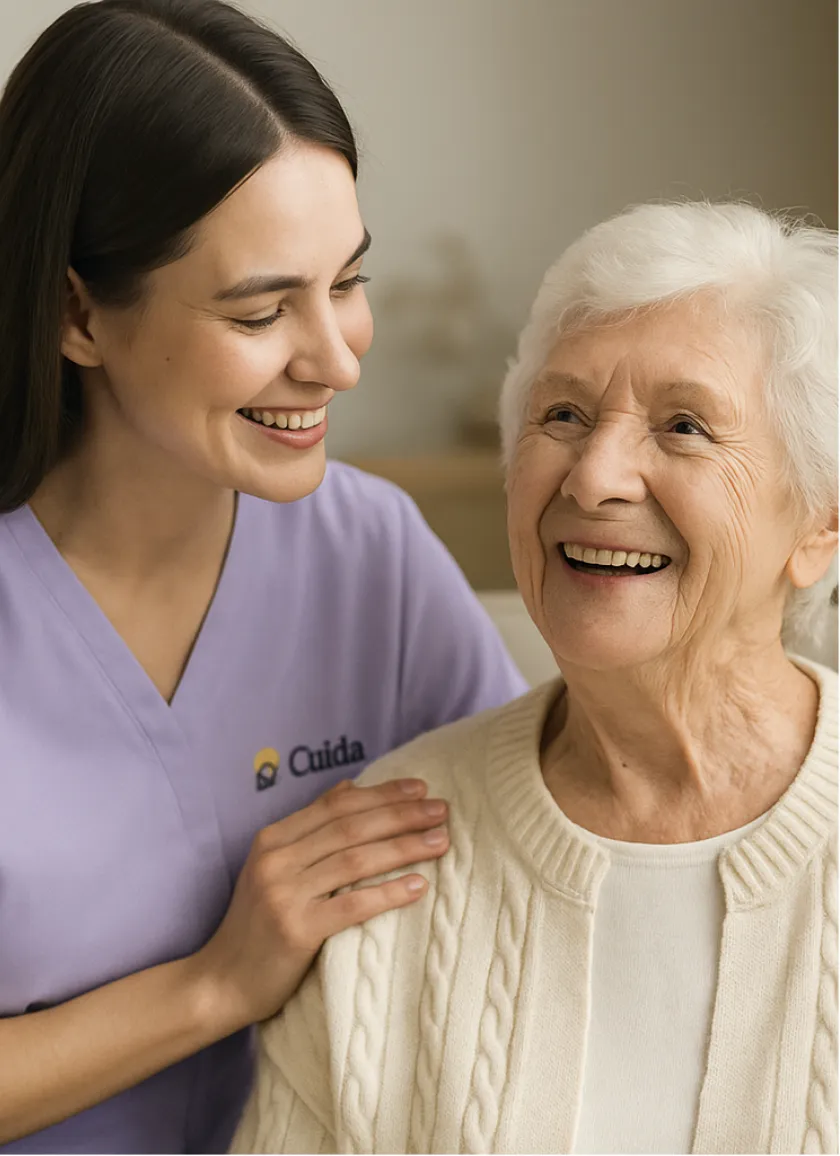 Cuidadora da Cuida Home Care sorrindo ao lado de uma senhora idosa